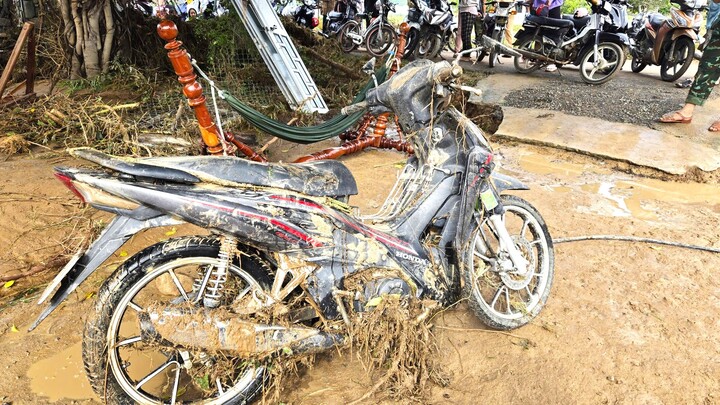 Một chiếc xe máy được người dân kéo ra khỏi bùn đất.