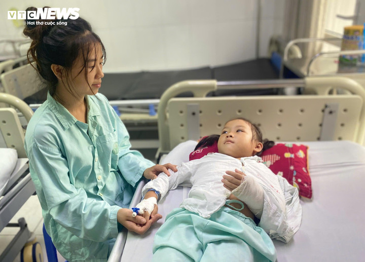 Chị Mai túc trực bên giường bệnh của con gái. (Ảnh: Phương Anh)