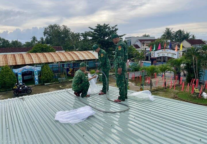 Lực lượng biên phòng gia cố mái trường học bằng cách cho nước vào các túi bóng.