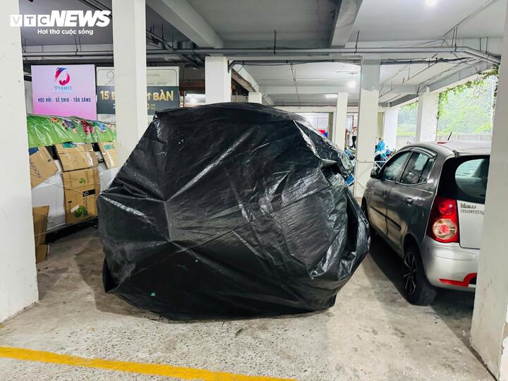 Xe ô tô tại các hầm chung cư cũng được người dân bọc bằng vải bạt chống nước, đề phòng nước dâng, tràn vào.