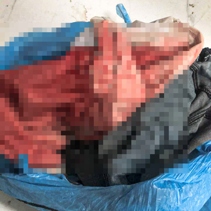 Chiếc áo trắng đồng phục thấm máu của con trai anh T. (Ảnh: NDCC)