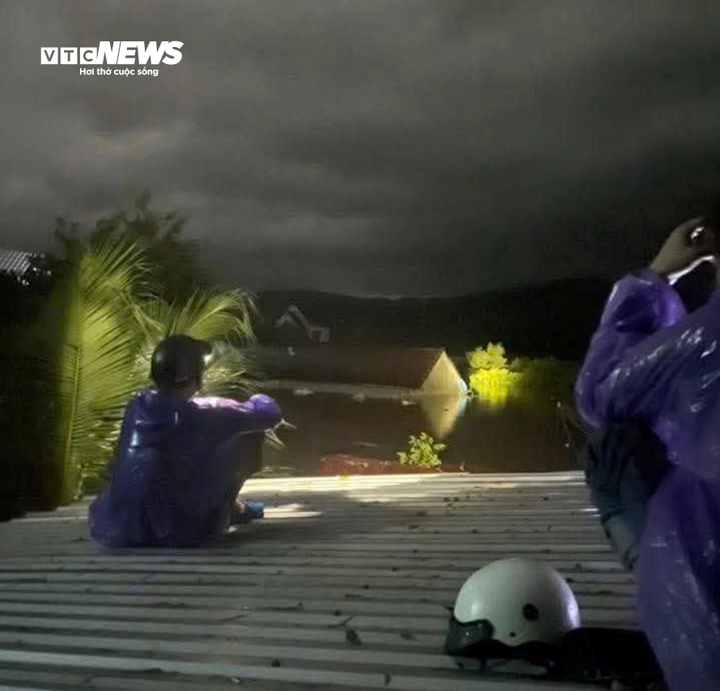 Người dân ngồi chờ trên mái nhà.