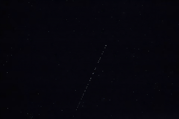 स्टारलिंक संचार उपग्रहों की एक श्रृंखला आकाश में प्रकाश की एक पट्टी के रूप में दिखाई देती है, जो एक अद्भुत दृश्य बनाती है। (स्रोत: रॉयटर्स)