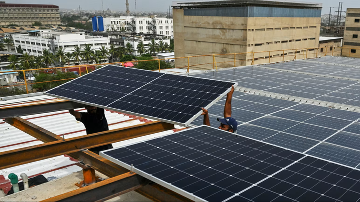 Kỹ thuật viên lắp đặt các tấm pin Mặt Trời trên mái một nhà máy ở thành phố cảng Karachi, Pakistan. (Nguồn: Getty Images)
