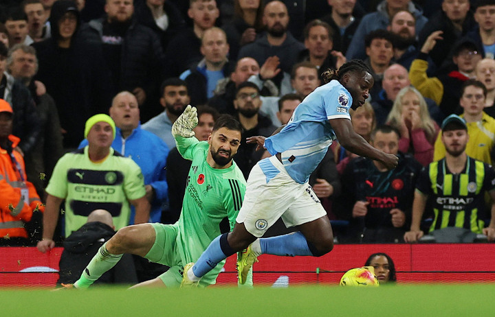 Doku vượt qua thủ môn Liverpool nhưng bị ngã. Man City chờ VAR. (Ảnh: Reuters)