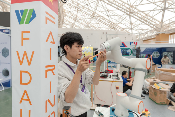 Một kỹ sư đang lắp đặt thiết bị in 3D tại không gian trưng bày Tuần lễ Công nghiệp & Công nghệ Việt Nam 2025.