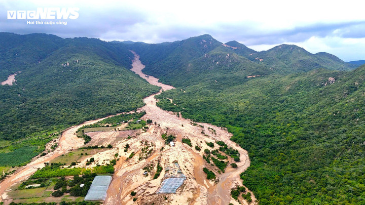 Vỡ hồ chứa nước ở xã Tuy Phong khiến đất đá từ trên núi tràn xuống khu vực vườn tược, dân cư bên dưới. Ảnh: THIÊN TRANG