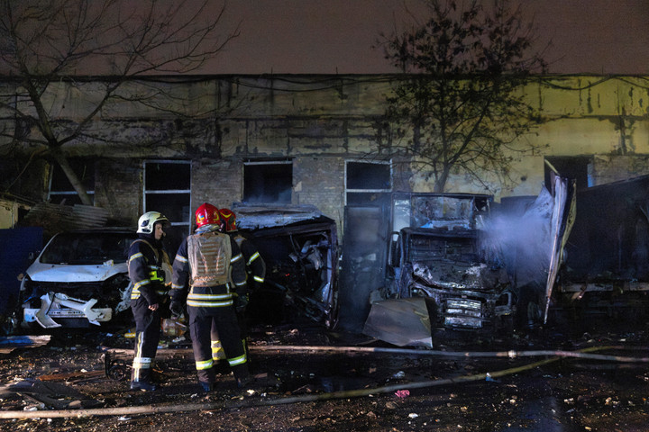Lính cứu hỏa đứng gần những chiếc ô tô bị cháy rụi tại hiện trường vụ va chạm sau cuộc tấn công bằng máy bay không người lái của Nga, ngày 8/11. (Ảnh: Reuters)