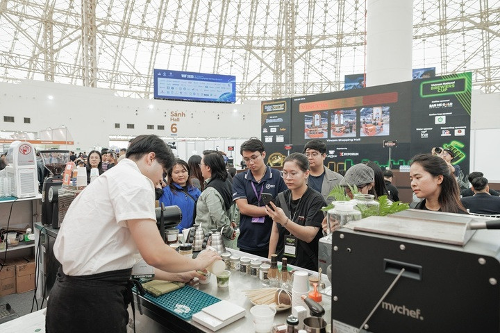 Khách tham quan chăm chú theo dõi một barista pha chế đồ uống tại Cafe Show Việt Nam.