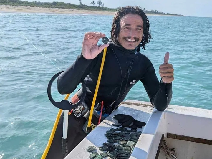 Thợ lặn Levin Shavers cùng những đồng tiền xu được tìm thấy từ một con tàu đắm ngoài khơi.