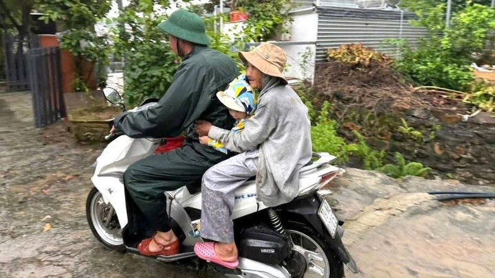 Chiến sĩ Đồn Biên phòng cửa khẩu cảng Nha Trang cơ động đưa người dân đến nơi an toàn. (Ảnh: Văn Tân).