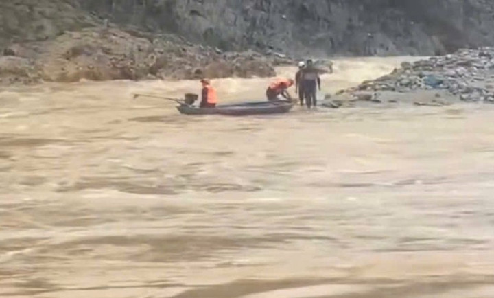 Lực lượng chức năng tiếp cận, giải cứu 2 người bị mắc kẹt trong lũ. (Ảnh: Đ.N)