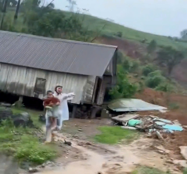 Cảnh người đàn ông ôm cháu nhỏ chạy thoát thân (ảnh cắt từ clip)