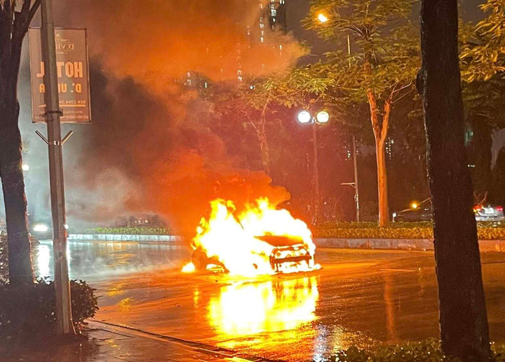 Ô tô bốc cháy ngùn ngụt dưới trời mưa.