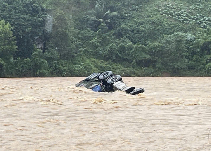 Chiếc xe tải bị lũ cuốn nằm cách cầu tràn khoảng 100 mét nhưng tài xế chưa rõ tung tích. (Ảnh: BPCC)