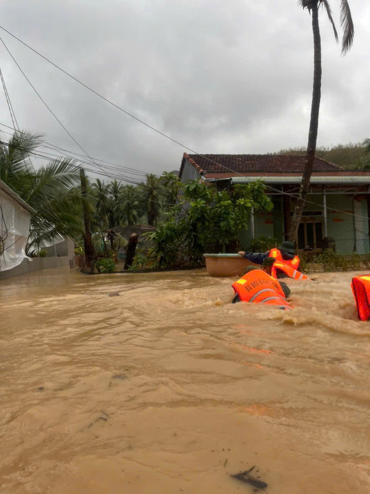 Lực lượng biên phòng bơi giữa dòng nước lũ để tiếp cận người dân.