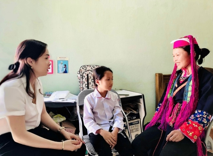 جاءت السيدة ثو (يسار) إلى المنزل للقاء وتشجيع وطرح الأسئلة على الطلاب وأولياء أمورهم من أقلية داو العرقية في العام الدراسي 2018-2019.