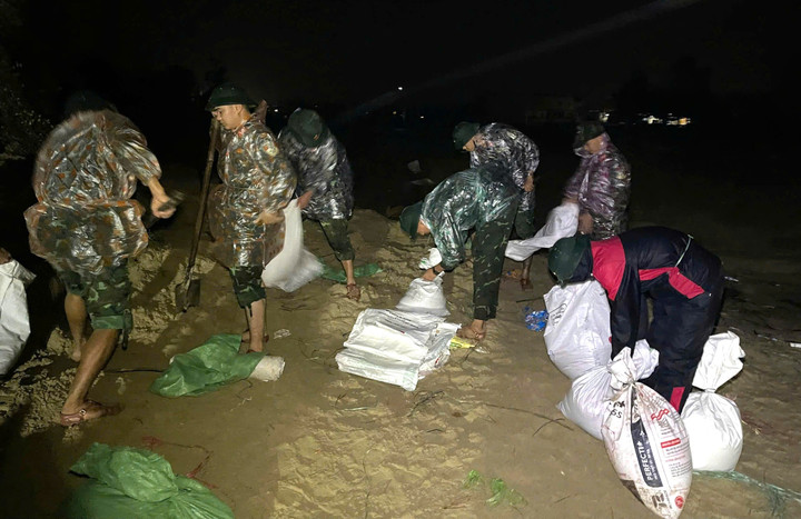 Trắng đêm, hơn 500 cán bộ, chiến sĩ đội mưa, hối hả "vá" những đoạn kè sạt lở bằng hàng nghìn bao cát. (Ảnh: Q.N)