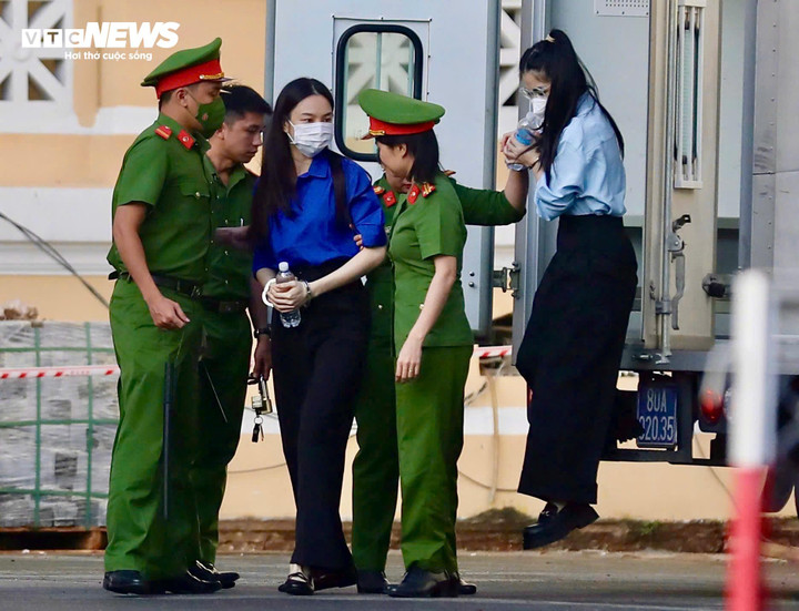 Bị cáo Nguyễn Thúc Thùy Tiên (áo xanh) và bị cáo Nguyền Thị Thái Hằng - Hằng Du Mục (áo trắng) được áp giải tới phiên tòa. (Ảnh: Hoàng Thọ)