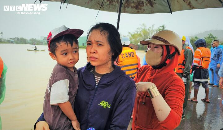 Hai mẹ con tại phường Quy Nhơn Đông sau một đêm chịu đói rét hoàn hồn khi được lực lượng cứu hộ đưa vào nơi an toàn.