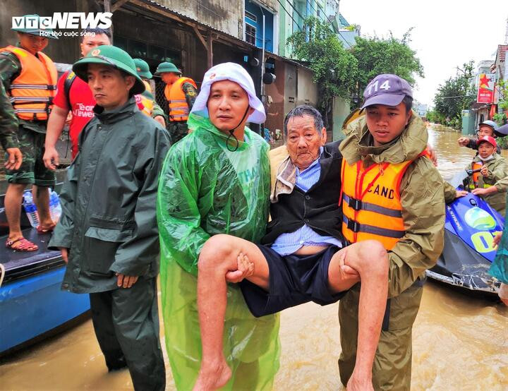 Một cụ ông thuộc phường Quy Nhơn Bắc được lực lượng chức năng đưa ra khỏi vùng lũ.