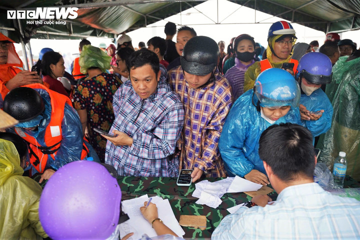 Bên trong lều, hàng trăm người xếp hàng khai báo với cán bộ phường về tình trạng người thân mắc kẹt trong mưa lũ để lập phương án ứng cứu.