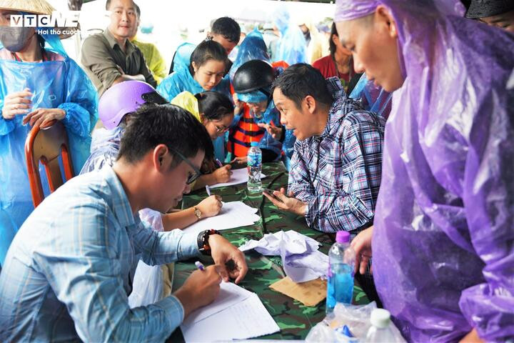Nhiều người xếp hàng khai báo trong lều về tình trạng người thân còn bị mắc kẹt trong mưa lũ để cơ quan chức năng lên phương án cứu trợ.