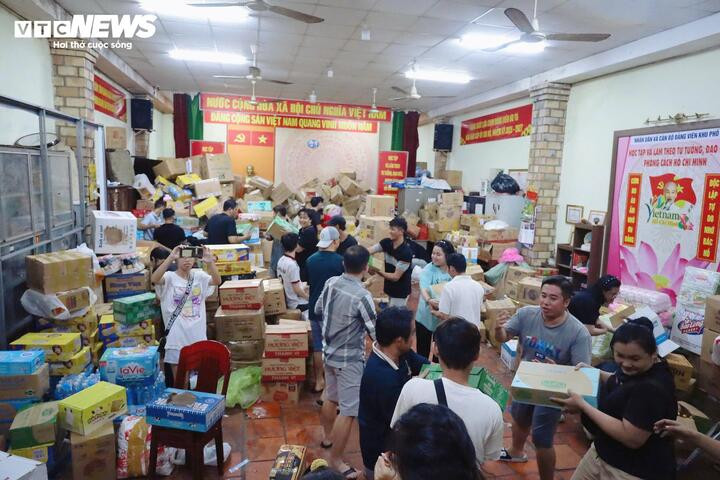 Hàng hoá cứu trợ gồm mì, sữa, bánh, nước suối... được các tình nguyện viên phân loại, sắp xếp.