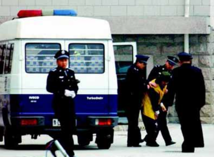 Cảnh sát áp giải Dương Tân Hải ra tòa ngày 1/2/2004. (Nguồn: China Daily)