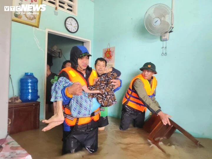 Những cụ già, trẻ nhỏ được bồng, cõng khỏi khu vực đang bị nước lũ bủa vây ở Gia Lai. (Ảnh: Minh Minh)