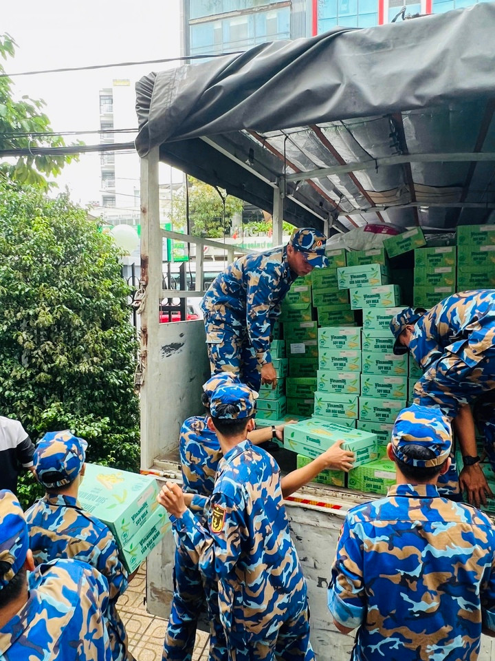 Các chiến sĩ Trung tâm Huấn luyện Vùng 4 Hải quân đang chuyền nhau các sản phẩm dinh dưỡng Vinamilk, sẵn sàng vận chuyển đến tận tay bà con vùng lũ. (Ảnh: Vi Nam)