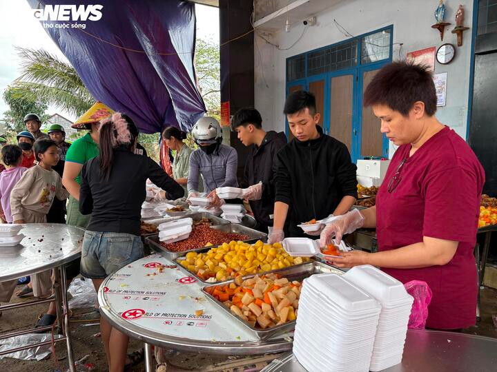 Từng suất cơm nóng hổi được đóng hộp cẩn thận trao cho bà con.