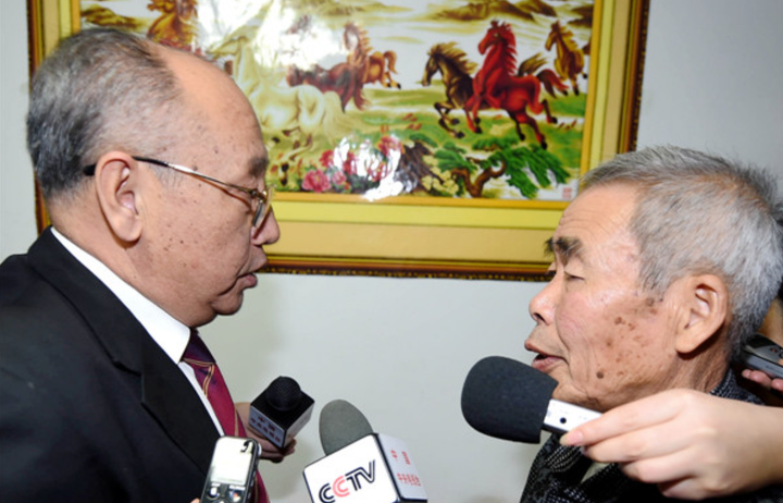 Phó Chánh án Tòa án Tối cao Nội Mông Cổ (trái) gửi lời xin lỗi tới cha của Huugjilt (phải). (Nguồn: Asianewsphoto)