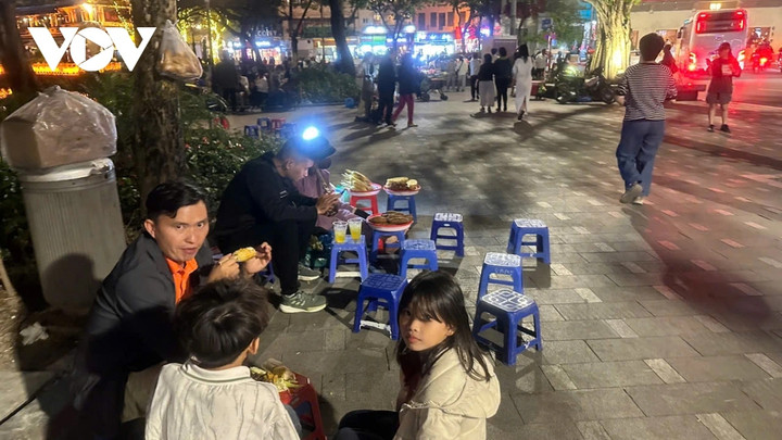 Tối 25/11, xung quanh bờ Hồ Hoàn Kiếm, bàn ghế, hàng quán, trải la liệt khiến lối đi bộ bị thu hẹp; rác thải và khói than lan tỏa khắp không gian.