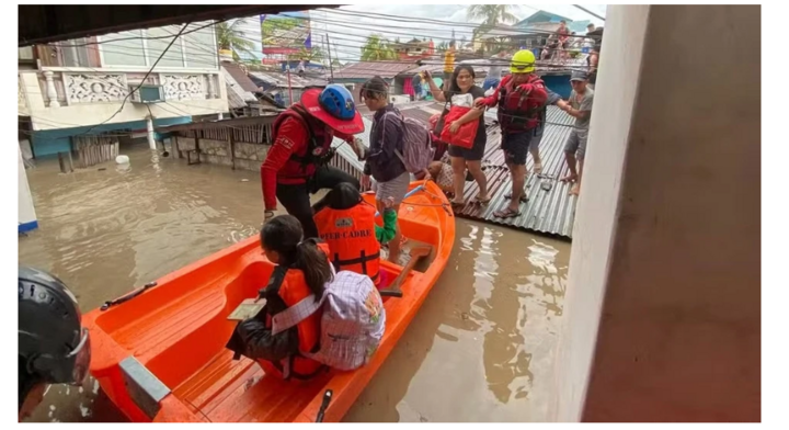 Lực lượng cứu hộ của Đơn vị Ứng phó Khẩn cấp thuộc Hội Chữ thập đỏ Philippines giải cứu những cư dân mắc kẹt trên mái các ngôi nhà bị ngập sâu tại Barangay Singcang Airport, thành phố Bacolod vào ngày 25/11. Ảnh: Bacolod.