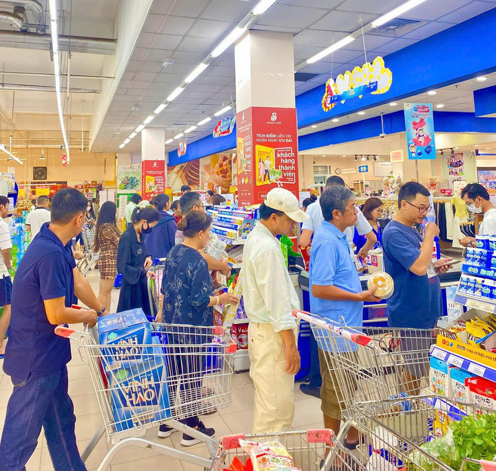 Khách hàng mua nước uống, mì gói và thực phẩm tiện dụng tại Co.opmart trong thời điểm địa phương phát cảnh báo ngập sâu.