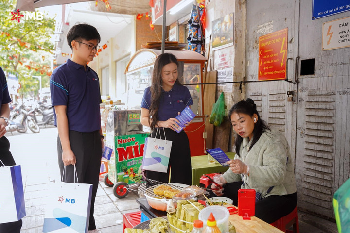 Nhân viên MB hướng dẫn tiểu thương chợ Hôm chuyển đổi số. (Ảnh: MB)