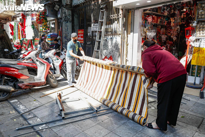 Nhiều mái che và khung sắt cơi nới tồn tại nhiều năm trên các tuyến phố ở phường Hoàn Kiếm đang được người dân phối hợp cùng lực lượng chức năng tháo dỡ. (Ảnh: Minh Đức)
