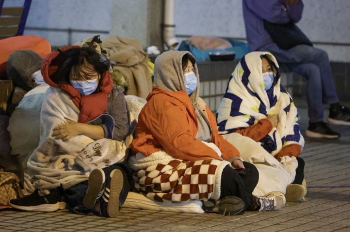 Người thân của những nạn nhân trong vụ cháy đang ngồi đợi tin tức. (Ảnh: Dickson Lee)