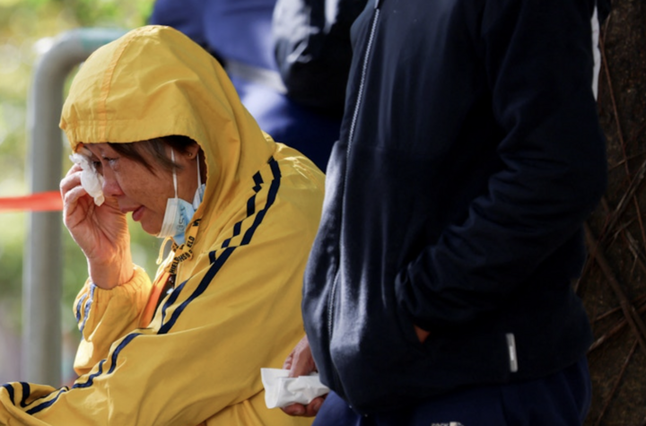 Một người phụ nữ đang chờ nhận diện thi thể người thân. (Ảnh: Reuters)