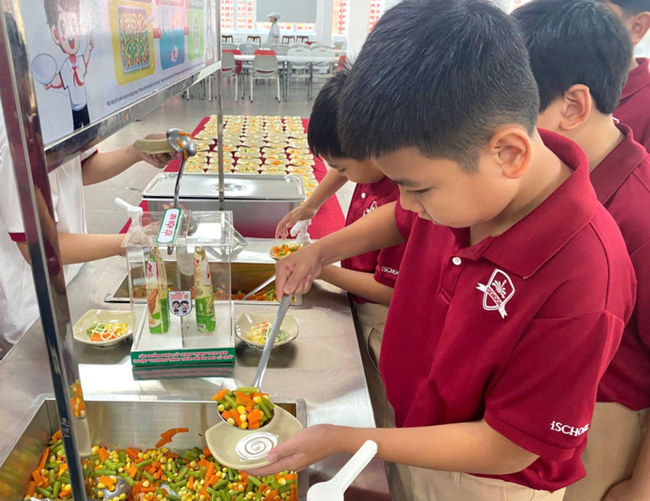 Học sinh trường iSchool Ninh Thuận hào hứng tự phục vụ món rau tại Quầy buffet rau.