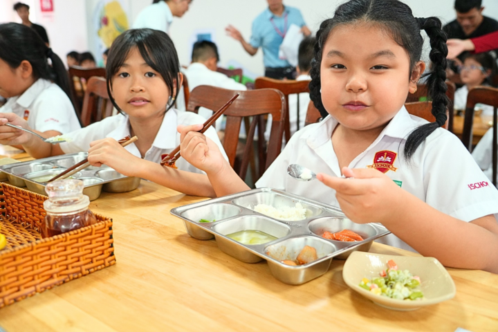 Các em học sinh vui vẻ thưởng thức bữa trưa nấu từ Phần mềm Dự án.