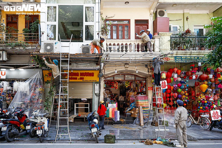 Ra quân dỡ mái che, dọn dẹp vỉa hè ở phố Hàng Mã. (Ảnh: Minh Đức)