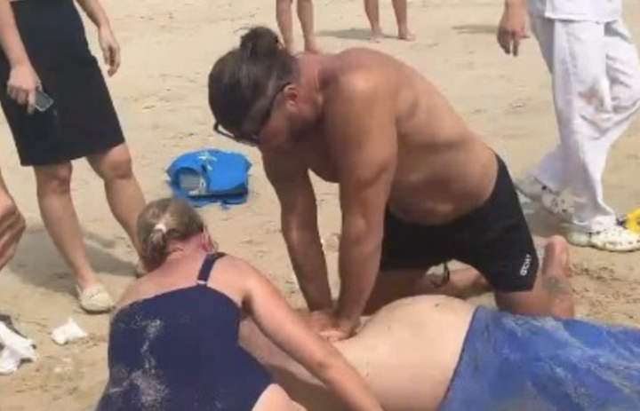 Các du khách hỗ trợ cấp cứu nạn nhân tại bãi biển. (Ảnh: L.S)