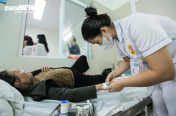 Nhân viên y tế chăm sóc người bệnh sốt xuất huyết. (Ảnh: Như Loan)