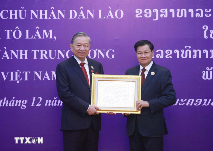 Tổng Bí thư, Chủ tịch nước Lào Thongloun Sisoulith trao tặng Huân chương Vàng Quốc gia của Nhà nước Lào cho Tổng Bí thư Tô Lâm. (Ảnh: Thống Nhất/TTXVN)