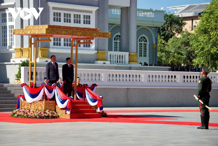 Tổng Bí thư, Chủ tịch nước Lào Thongloun Sisoulith mời Tổng Bí thư Tô Lâm bước lên bục danh dự. Quân nhạc cử Quốc thiều hai nước.