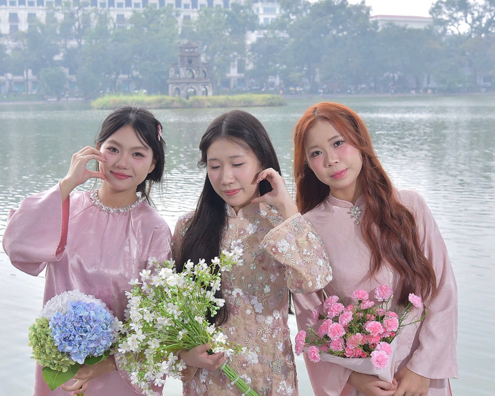 Thu Hang (längst till vänster) och hennes vän tog ett foto vid Hoan Kiem-sjön den 2 december (Foto: NVCC)