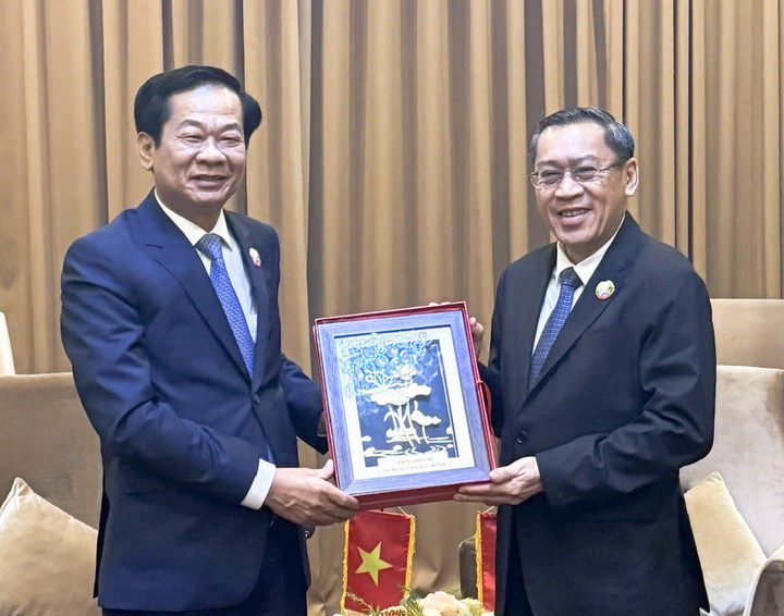 Bộ trưởng Bộ Nội vụ Việt Nam Đỗ Thanh Bình và Bộ trưởng Bộ Lao động và Phúc lợi xã hội Lào Phosay Sayasone trao quà lưu niệm. (Ảnh: Bộ Nội vụ)