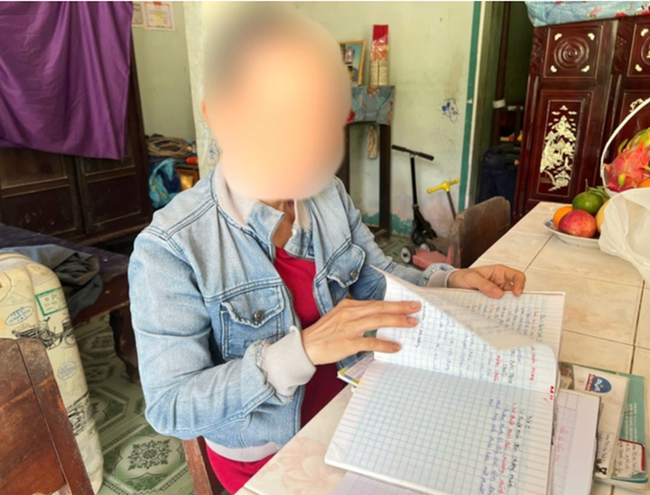 Bà N.T.H (mẹ ruột nữ sinh) đau lòng khi lật từng trang tập của con gái.